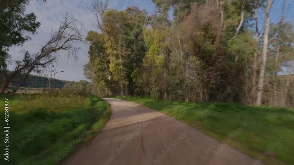 in southern Spain, a drone speeds down a dirt road between an olive orchard and the Guadalquivir River in southern Spain, a drone speeds down a dirt road between an olive orchard and the Guadalquivir River