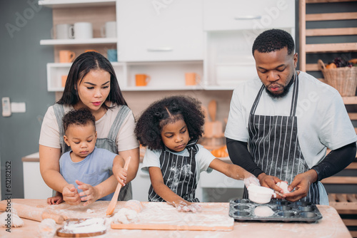 Family members cook homemade pizza dough in funny and playful ways. Mixing ingredients like salt, sugar, milk, yeast, oil then rubbing, massaging, pressing bread flour to make it smoother, stretchier