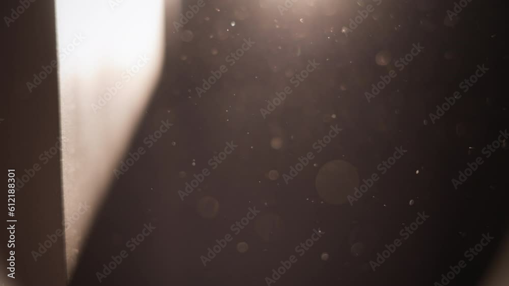 Sunlight from the window shining on the wall revealing dust particles in the air. Slow motion. 