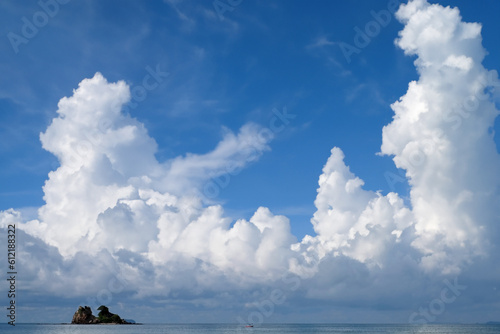 White fluffy clouds with blue sky and little island landscape background	