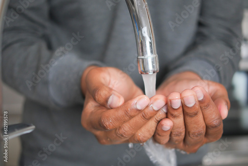 young man washing hands with soap warm water 