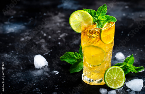 Dark and Stormy alcoholic cocktail drink with dark rum, ginger ale, lime and ice, black bar counter background photo
