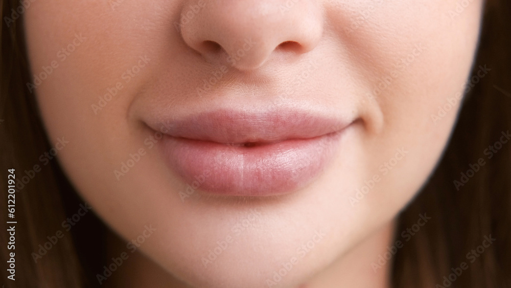 Lip plumping. Female beauty. Macro view portrait. Happy unrecognizable woman with nude puffy mouth pretty smiling closeup. Lip plumping. Female beauty. Macro view portrait. Happy unrecognizable woman with nude puffy mouth pretty smiling closeup.