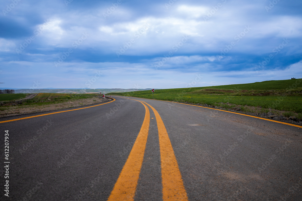 Beautiful empty winding road with signpost Beautiful empty winding road with signpost