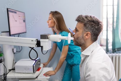 Man performing pulmonary function test and spirometry using spirometer at medical clinic. Spirometry of lungs photo