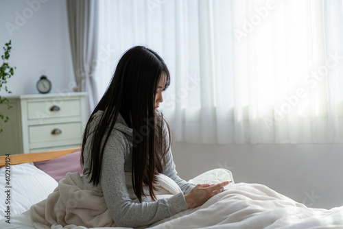 ベッドに座る若い日本人女性 photo