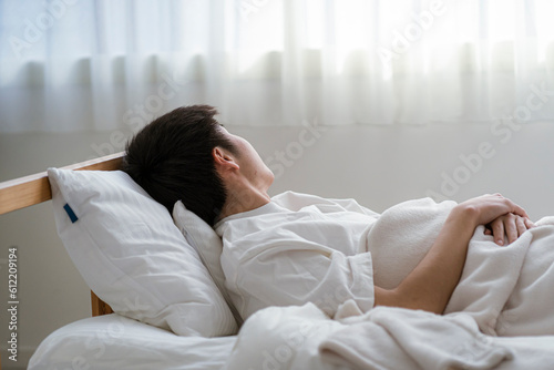 ベッドに横になる若い日本人男性
