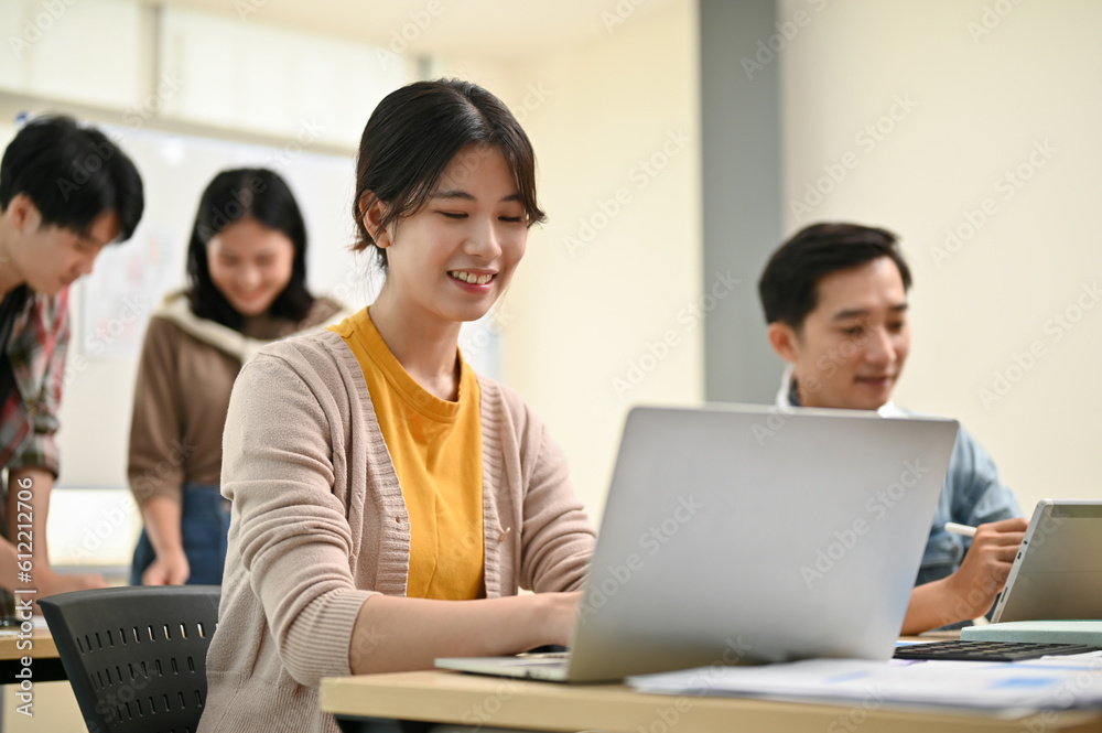 A female worker in a startup team is working on her tasks on hera laptop A female worker in a startup team is working on her tasks on hera laptop