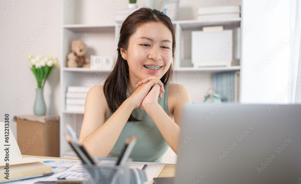 Young Asian female student watching teacher's live performance or video call on laptop in classroom at home, Conversations with teachers and classmates, Online learning, Study at your own home. Young Asian female student watching teacher's live performance or video call on laptop in classroom at home, Conversations with teachers and classmates, Online learning, Study at your own home.