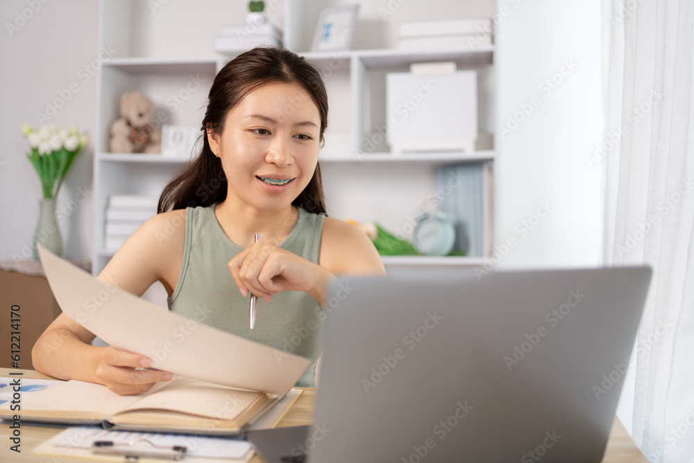 Young Asian female student watching teacher's live performance or video call on laptop in classroom at home, Conversations with teachers and classmates, Online learning, Study at your own home. Young Asian female student watching teacher's live performance or video call on laptop in classroom at home, Conversations with teachers and classmates, Online learning, Study at your own home.