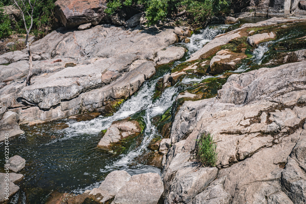 Obraz premium Waterfall on the river Ingulets in Krivoy Rog, Ukraine. A unique miracle of nature, water flows over stones at the Karachunovsky reservoir
