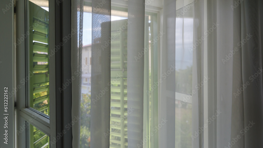 Window shutters and curtains at seaside apartment