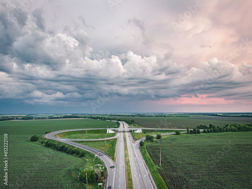 Thunderclouds gather over the road leading along the fields, creating a very magical landscape.