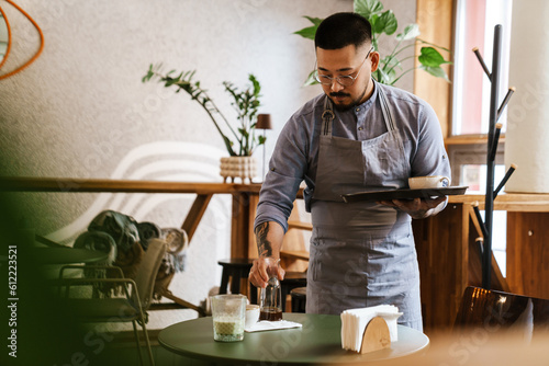 Εκτύπωση καμβά Waiter removing dirty dishes from tables in cafe
