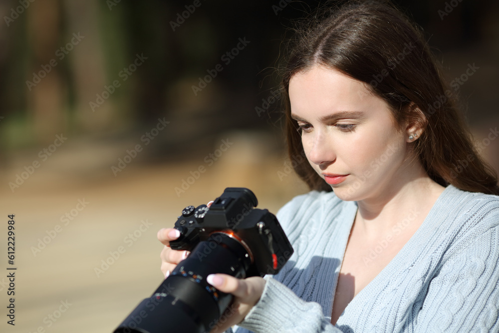 Photographer checking pictures on mirrorless camera Photographer checking pictures on mirrorless camera