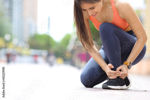 Obraz na płótnie Runner suffering ankle ache in the street