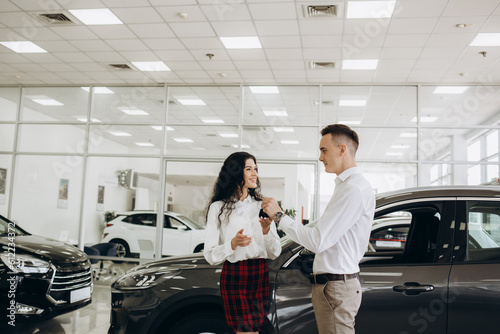 Young couple buying a car in the showroom © Roman