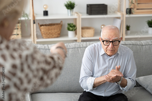 Фотография Unrecognizable woman menacing submissive elderly man