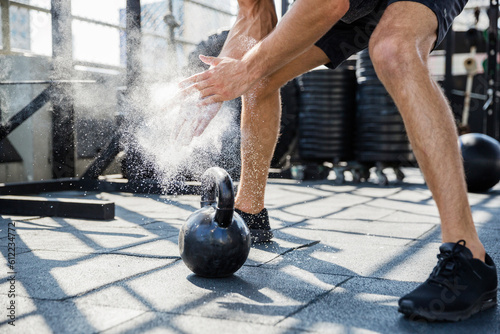 Man dusting sports chalk exercising at rooftop gym