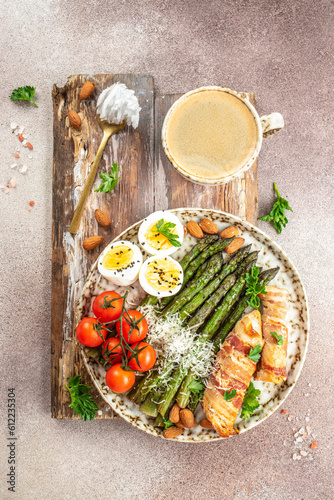 Ketogenic menu. Baked chicken breast wrapped in bacon with asparagus, eggs and tomatoes. bulletproof coffee with MCT coconut oil. top view