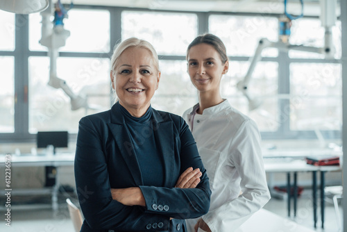 Happy businesswoman standing by colleague in laboratory photo