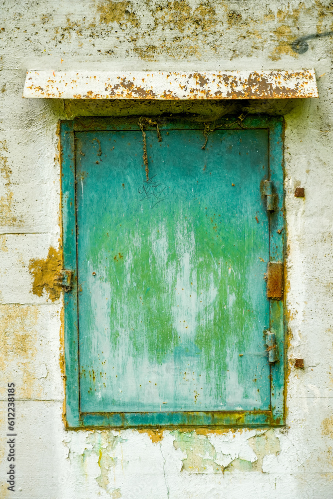 Old green metal window on an abandoned bunker.
Old green metal window on an abandoned bunker.