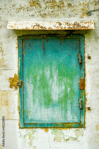 Old green metal window on an abandoned bunker.  © Elly Miller