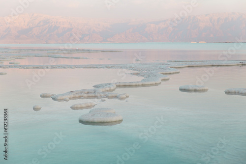 Salt formations in dead sea at sunset photo