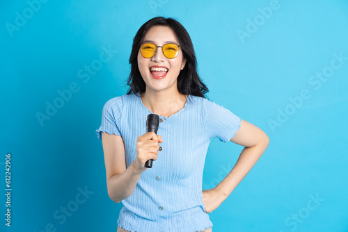 Portrait of smiling asian woman posing on blue background