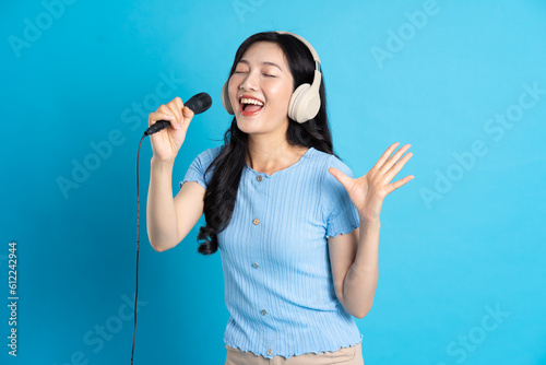Portrait of smiling asian woman posing on blue background photo