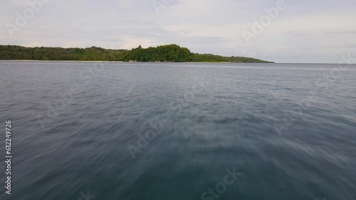 Flying fast and low over the water surface of the ocean towards Mentawai island, Indonesia photo