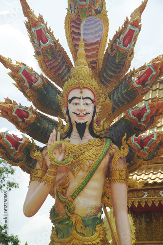 Statue of a standing angel with a serpent covering the back, guarding and decorating the place of Wat Maneewong. Journey to pay homage to the sacred things. photo