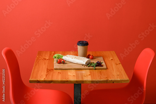 Prepared shawarma on a wooden board with cherry tomatoes and lettuce.