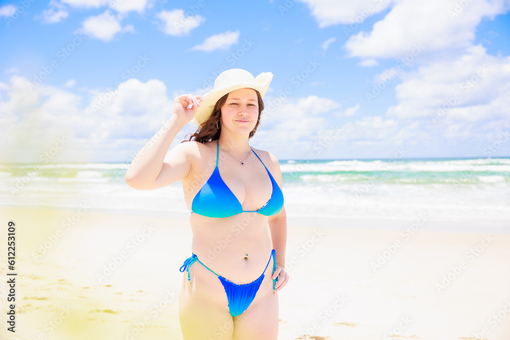 真夏の海と帽子をかぶった青い水着の白人少女