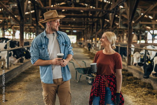 Young couple working together in a stable and drinking coffee.