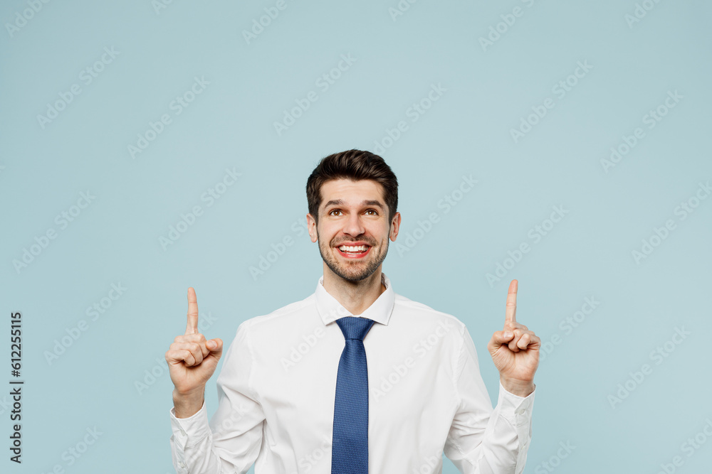 Young fun employee business man corporate lawyer in classic formal shirt tie work in office point index finger overhead on area mock up isolated on plain pastel light blue background studio portrait Young fun employee business man corporate lawyer in classic formal shirt tie work in office point index finger overhead on area mock up isolated on plain pastel light blue background studio portrait