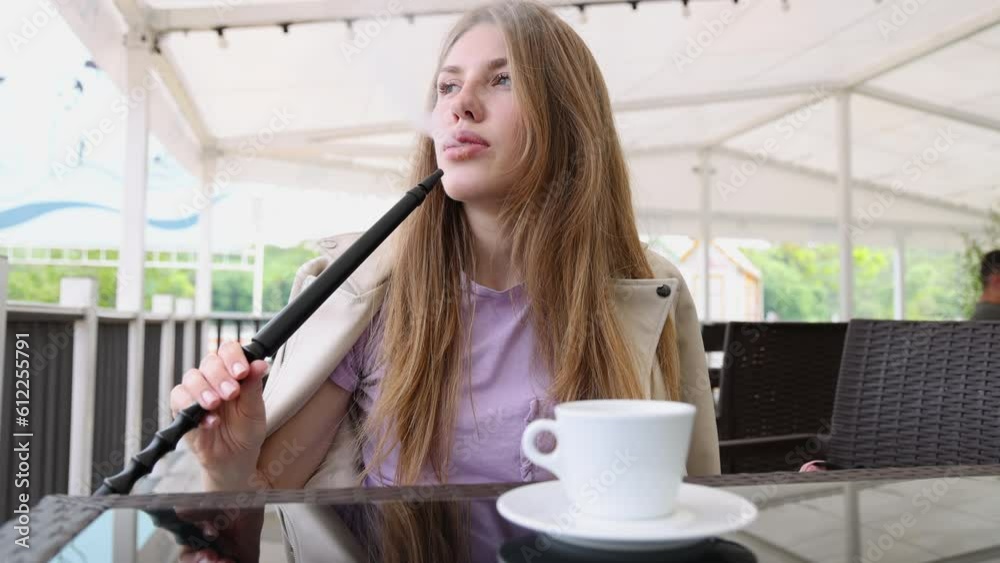 girl woman smoking hookah in terrace restaurant sitting with coffee cup on table,typing message on phone.female with cold sore herpes hpv virus on lips 4k.hookan man putting coal cubes on tabaco bowl girl woman smoking hookah in terrace restaurant sitting with coffee cup on table,typing message on phone.female with cold sore herpes hpv virus on lips 4k.hookan man putting coal cubes on tabaco bowl