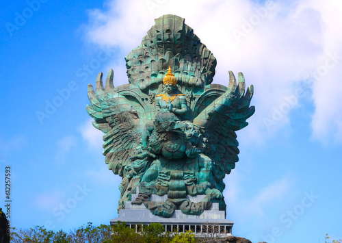 A portrait of Garuda Wisnu Kencana statue, an iconic cultural landmark in Bali, at the GWK Cultural Park with blue sky as background