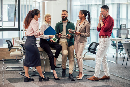 A business team is standing in a modern office and having a discussion