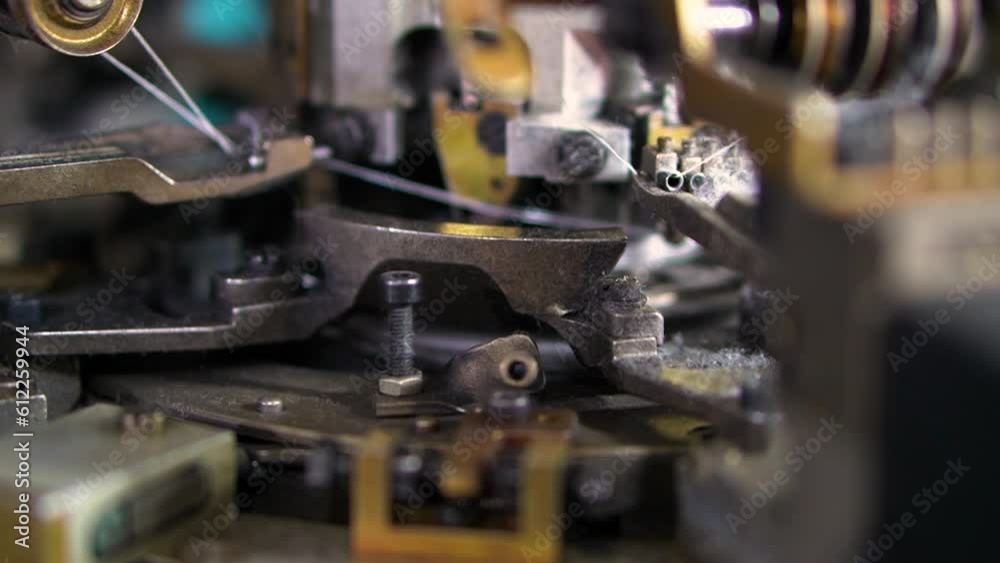 Close-up parts of the machine with threads, the Production process in a socks production factory, automated process, manufacture of clothing Close-up parts of the machine with threads, the Production process in a socks production factory, automated process, manufacture of clothing