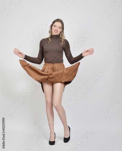 Photos junge frau cool modisch rock kleid hebt hoch lüftet beine rasiert