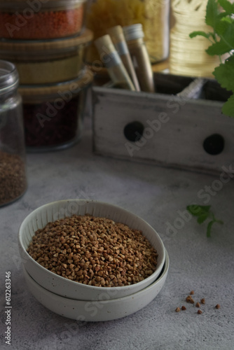 Buckwheat in a bowl on table against rustic decor background