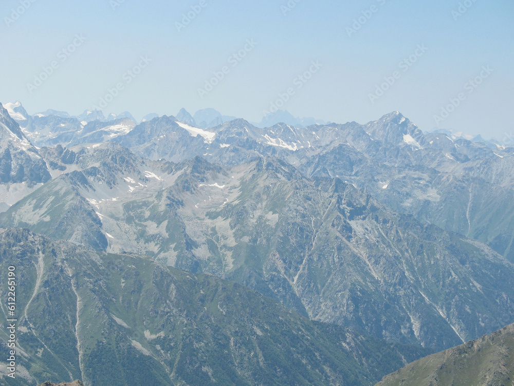 Aerial panoramic view of the Main Caucasus Mountain Ridge from Mount Elbrus, the highest summit in Europe, glacier Seven, incredible blue sky background, impressive nature landscape in North Caucasus