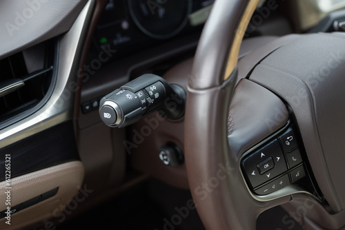 Multifunction Headlight Console Control Switch knob. The light knob in the car. Fog light switch. Car front headlight headlamp control stick on the left side of steering wheel. Car with light switch © uflypro