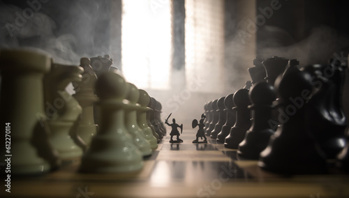 Fototapeta Medieval battle scene with cavalry and infantry on chessboard. Chess board game concept of business ideas and competition and strategy ideas Chess figures on a dark background with smoke and fog.