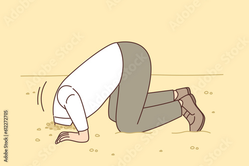 Man hides head in sand like ostrich from proverb, for concept of denial of problems and cowardice