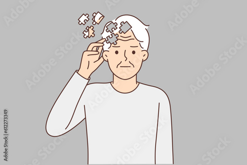Elderly man with puzzles near head, symbolizing dementia, suffers from memory problems or alzheimer