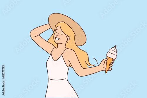 Girl with ice cream in waffle cone enjoys summer holidays and hot sunny weather.