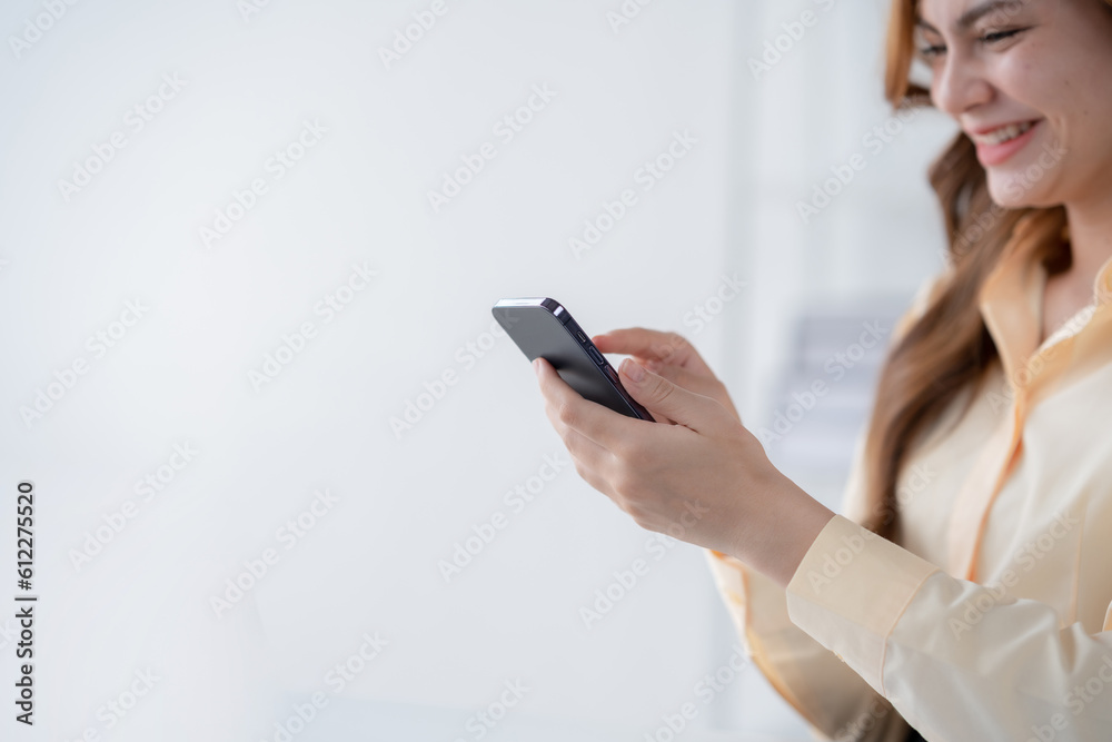 Beautiful smiling businesswoman using a smartphone to work on various application including mobile transaction to send messages, LINE, and various business information sent via social media. Beautiful smiling businesswoman using a smartphone to work on various application including mobile transaction to send messages, LINE, and various business information sent via social media.
