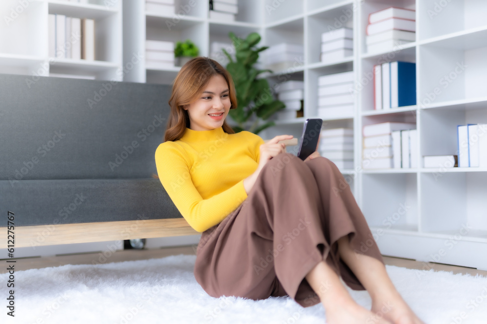 Cute young woman sit on sofa and using smartphone at home. Female using mobile phone, watching movie, listening to music, shopping online, watching live broadcast. Cute young woman sit on sofa and using smartphone at home. Female using mobile phone, watching movie, listening to music, shopping online, watching live broadcast.